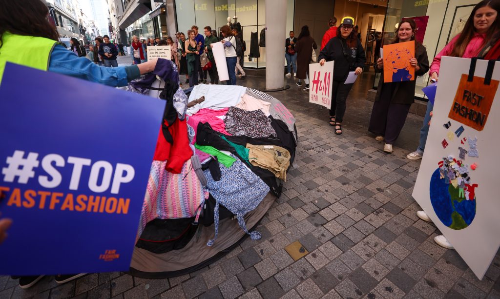 Activistas con pancartas «stop fast fashion» participan en una protesta frente a la tienda de ropa H&M en la Rue Neuve de Bruselas, el 30 de septiembre de 2023.