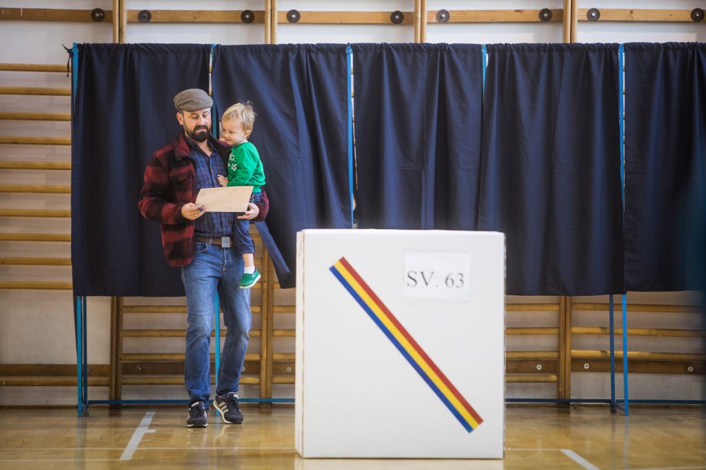 Un hombre con su niño pequeño en un colegio electoral rumano durante la primera vuelta electoral.