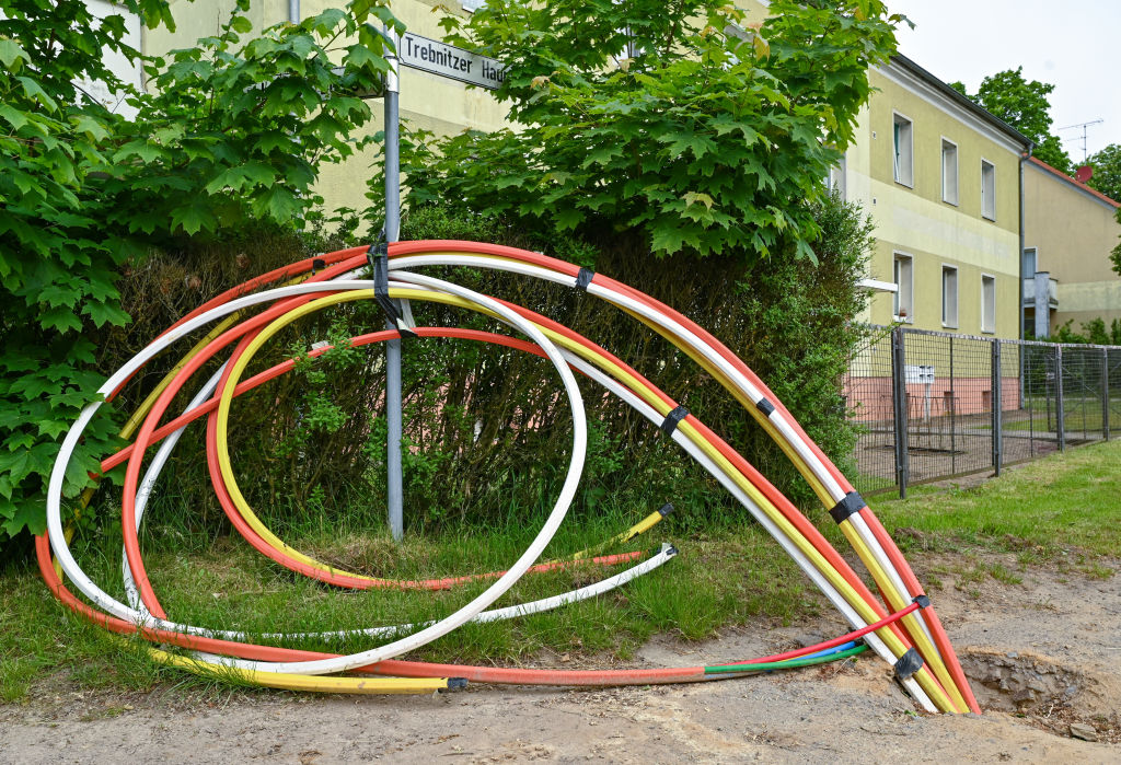 Tuberías de colores vacías, en las cuales se instalarán cables de fibra óptica, sobresalen del suelo a lo largo de una calle en Berlín, el 2 de junio de 2021.