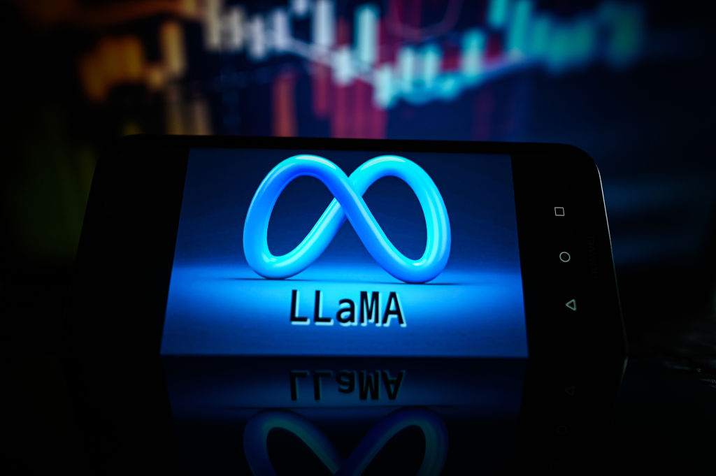 Logotipo de LLaMA de META en un smartphone con porcentajes bursátiles de fondo.
