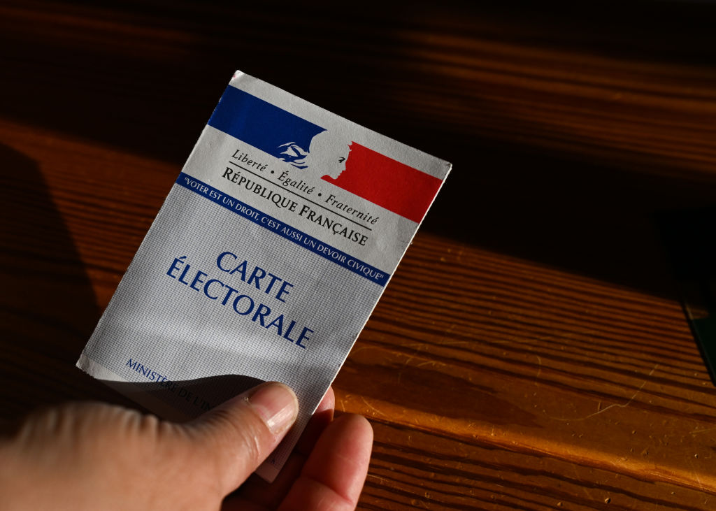Un votante muestra su tarjeta electoral en el ayuntamiento de Saint-Vaast-sur-Seulles, colegio electoral de la 1ª circunscripción de Calvados, durante la primera vuelta de las elecciones legislativas francesas, el 30 de junio de 2024.