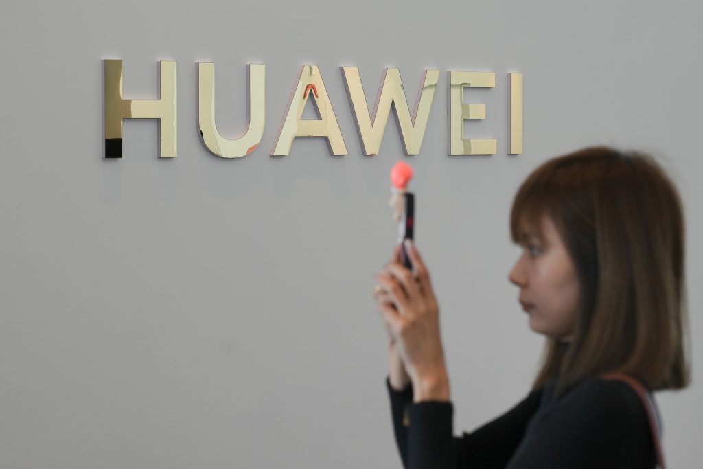 Una mujer hace fotos con un móvil ante el logotipo de Huawei durante un acto de presentación de un producto en Kuala Lumpur, Malasia, el 18 de febrero de 2025.