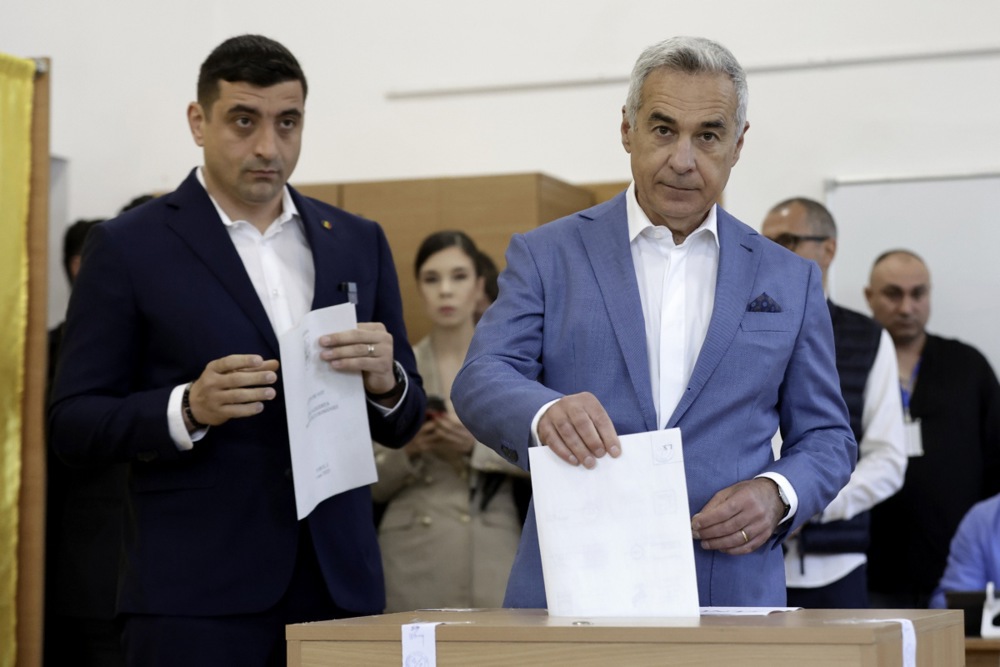 El candidato presidencial y líder del partido de extrema derecha Alianza para la Unión de los Rumanos (AUR), George Simion (izq.), y el ex candidato presidencial Calin Georgescu, ahora inhabilitado para la carrera presidencial, depositan su voto en la primera vuelta de las elecciones presidenciales en Mogosoaia, cerca de Bucarest, el 4 de mayo de 2025.