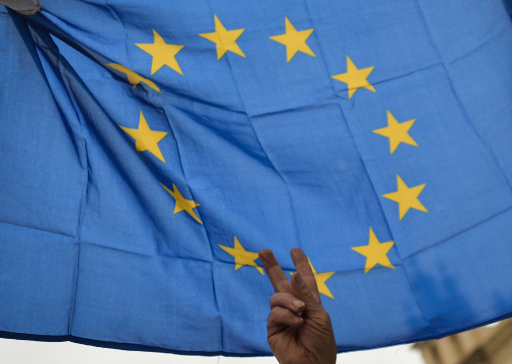 Un miembro del Comité para la Defensa de la Democracia en Polonia (KOD) sostiene una bandera de la UE durante una manifestación organizada en la Plaza del Mercado Principal de Cracovia el 9 de junio de 2020.