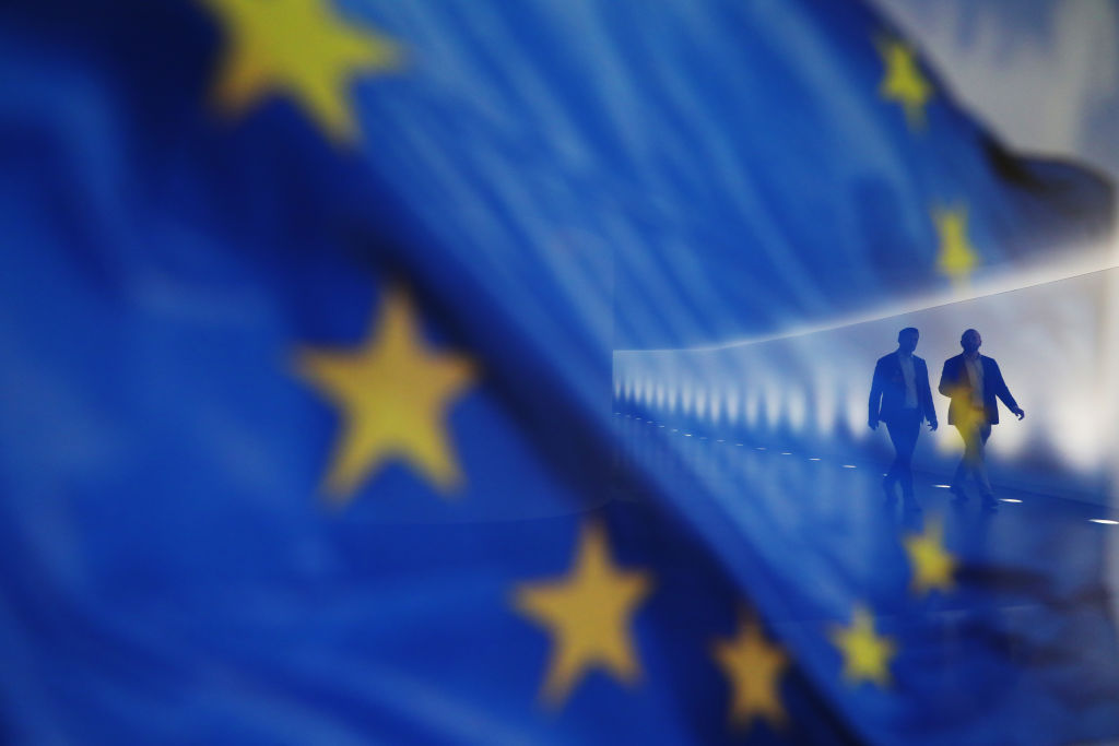 Varias personas caminan junto a una bandera europea en el Bundestag, la Cámara Baja del Parlamento alemán, en Berlín, el 26 de junio de 2024.