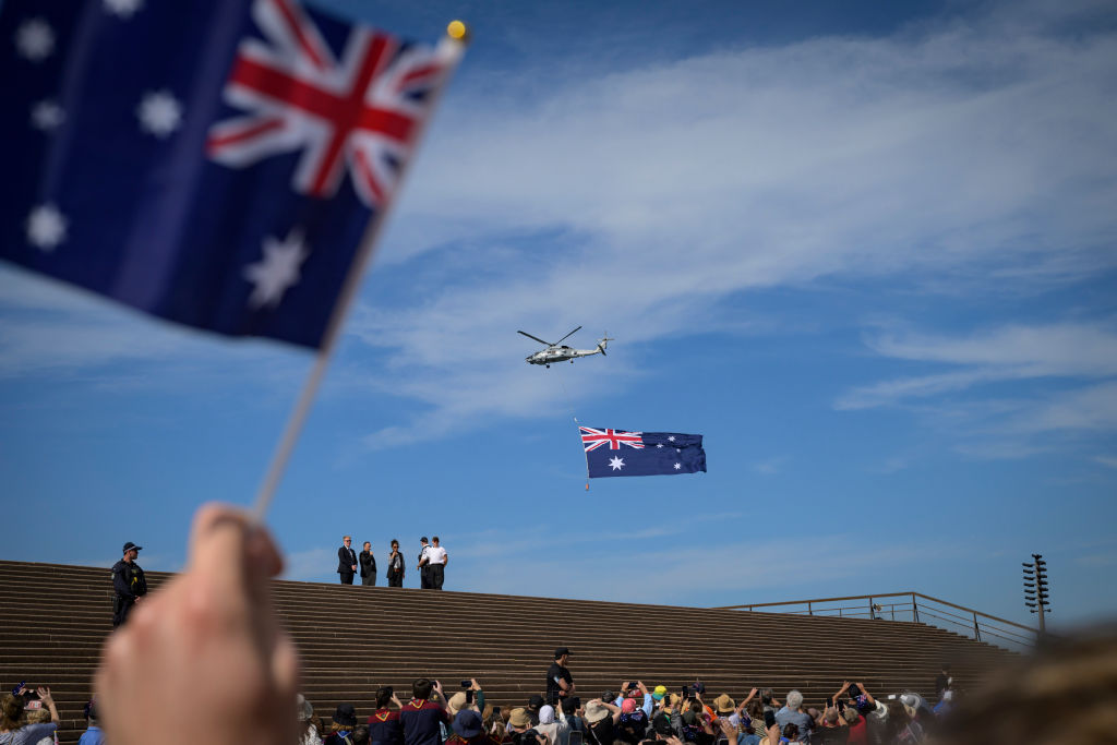 Un helicóptero con la bandera nacional australiana sobrevuela la Ópera de Sidney, el  22 de octubre de 2024.