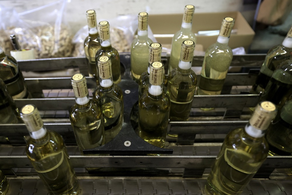 Varios empleados despachan paquetes en la sección de embotellado de una bodega en Aumelas, sur de Francia, el 18 de marzo de 2025.