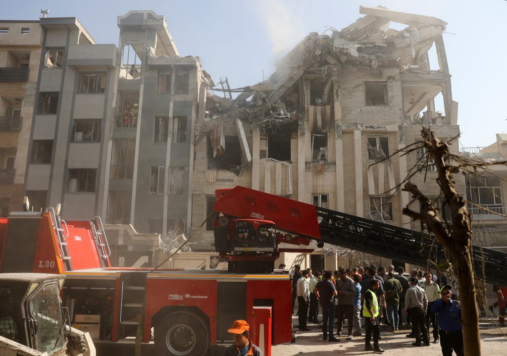 Equipos de rescate trabajan entre las ruinas de un edificio blanco de los ataques israelíes del 13 de junio, en Teherán