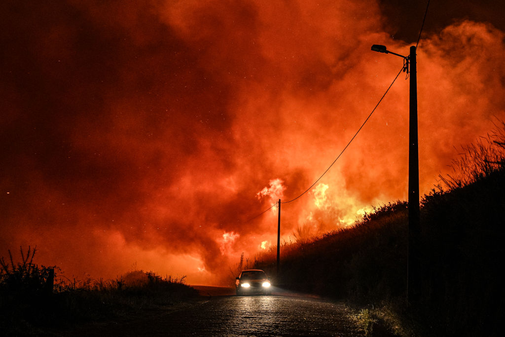 Residentes del pueblo de Almofrela, en Baiao, Portugal, escapan en un choche de los graves incendios forestales del 17 de septiembre de 2024 en esa zona.