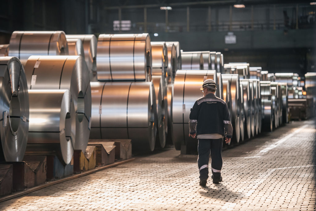 Un trabajador pasa junto a bobinas de acero terminado en la acería de Thyssenkrupp el 20 de marzo de 2025 en Duisburgo, Alemania.