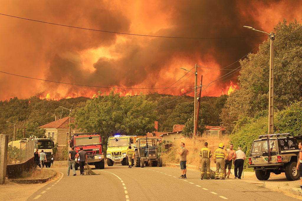 Bomberos y residentes locales luchan contra el incendio forestal en la región de Cualedro, en la provincia de Ourense, el 15 de agosto de 2025.