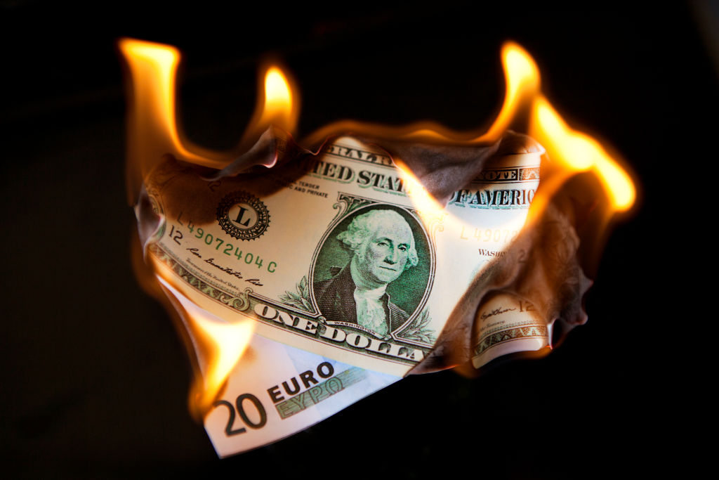 Billetes de euro y dólar quemándose, en una ilustración fotográfica de 2011.