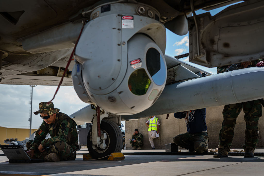 Un técnico afgano calibra el sistema de vigilancia por cámara de un avión A-29 antes de que despegue para una misión, en la base aérea de Kandahar, en Kandahar, Afganistán, el jueves 6 de mayo de 2021.