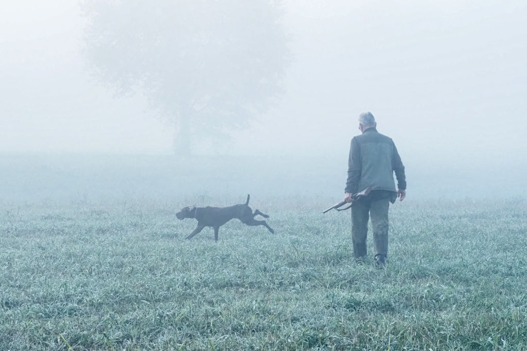 Hunter with his dog surrounded by fog, during the first day
