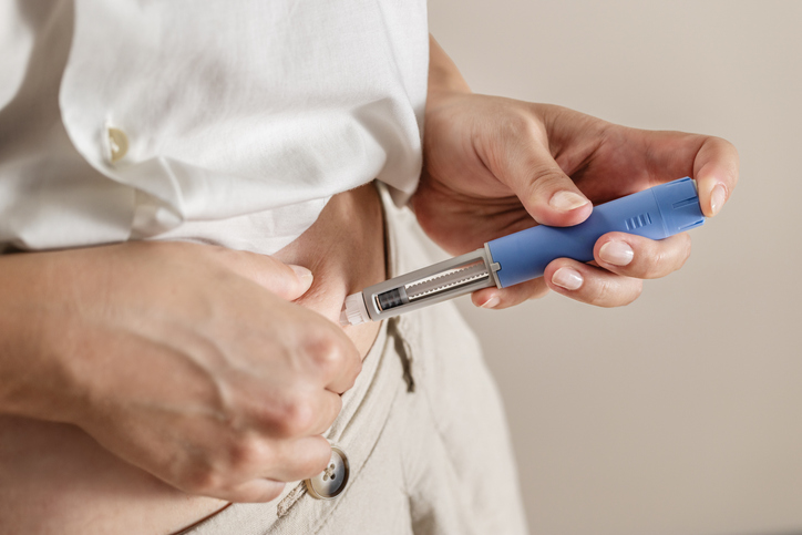 Woman using injection pen.