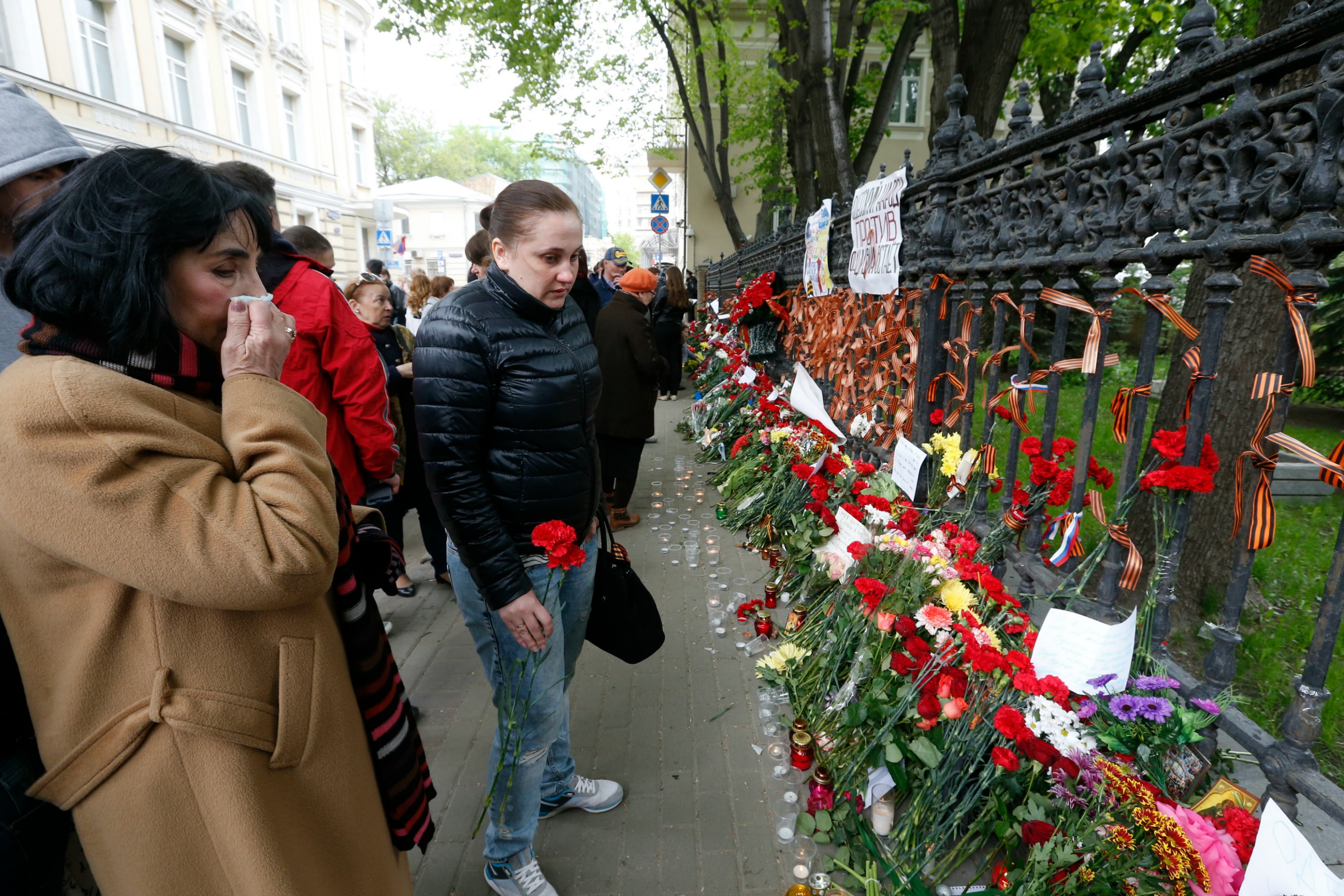 People bring flowers, lit candles and black and orange ribbons of St. George to mourn the death in Odessa, at the gate of the Ukrainian embassy in Moscow. Photo Reuters