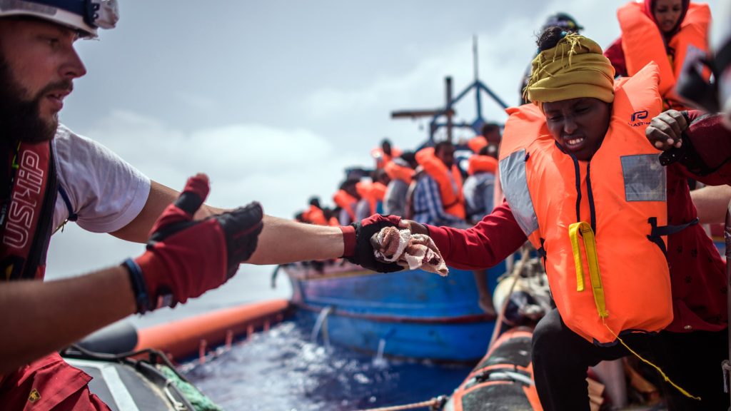 epaselect epa06683385 Members of the NGO &lsquo;SOS Mediterranee&rsquo; from the &lsquo;Aquarius&rsquo; vessel help a woman during an operation to rescue more than 250 migrants on a wooden boat, about 50 kilometers off the Libyan coast, in the Mediterranean Sea, 21 April 2018. The Aquarius crew led two operations on 21 April and rescued some 350 people on addition of the 164 rescued last week and already on board.  EPA-EFE/CHRISTOPHE PETIT TESSON