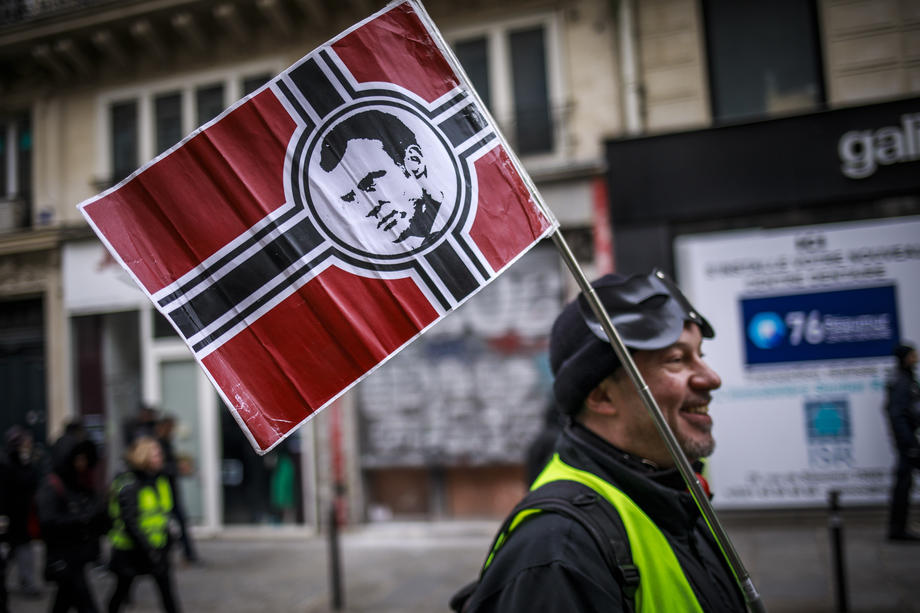Un manifestant des Gilets jaunes, portant un étendard caricaturant Emmanuel Macron en nazi, le 28 décembre 2019 à Paris.EPA-EFE/CHRISTOPHE PETIT TESSON