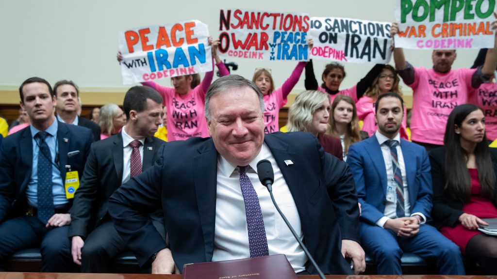 epaselect epa08255714 Protesters are seen behind US Secretary of State Mike Pompeo (C) as he arrives to testify before the House Foreign Affairs Committee hearing on &lsquo;Evaluating the Trump Administration&rsquo;s Policies on Iran, Iraq and the Use of Force&rsquo;, on Capitol Hill in Washington, DC, USA, 28 February 2020. The US is poised to sign an agreement with the Taliban that would mean a reduction in the presence of US troops, 29 February, on the stipulation that a week-long reduction in violence is successful.  EPA-EFE/MICHAEL REYNOLDS