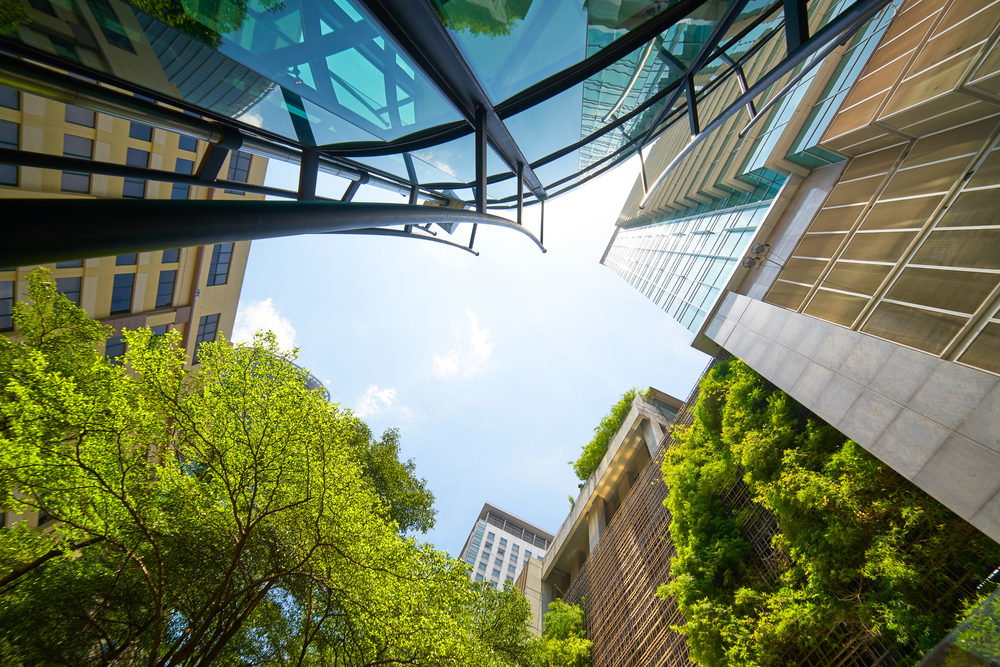 Low,Angle,Shot,Of,Modern,Glass,Buildings,And,Green,With