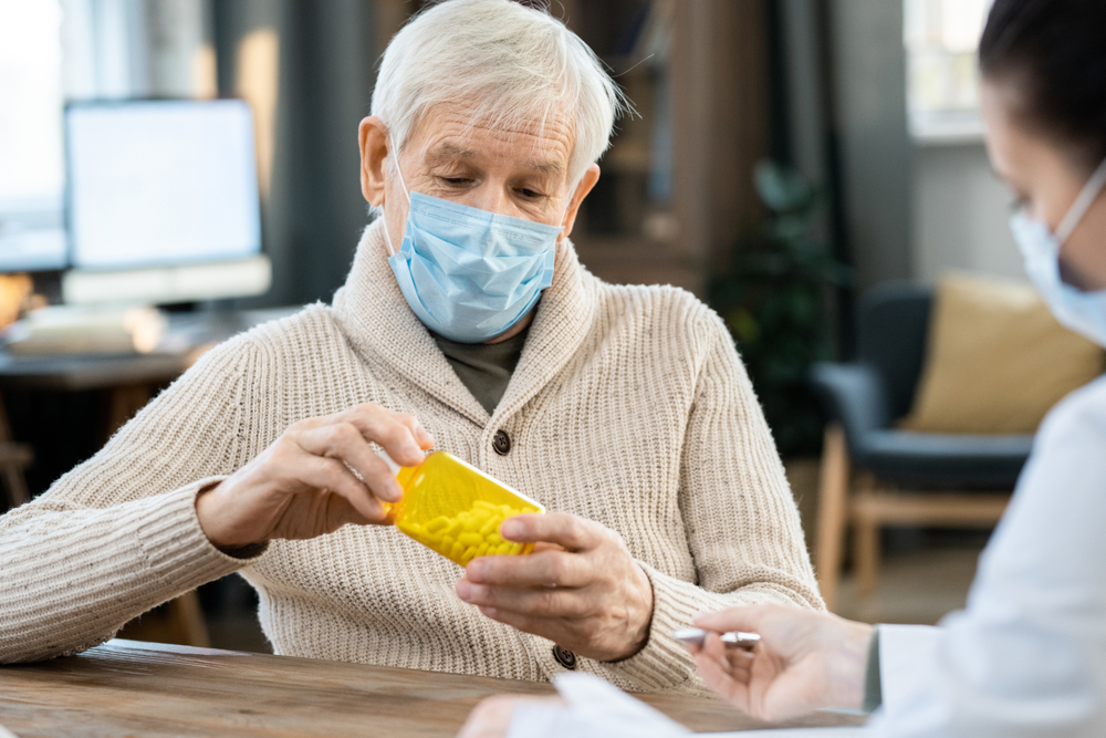 Senior,Man,In,Casualwear,And,Mask,Looking,At,Bottle,Of