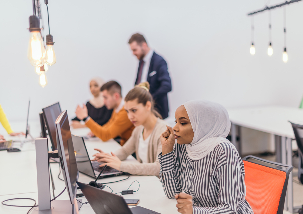 Group,Of,Multi-ethnic,Colleagues,Working,On,Desktop,Computers,In,A