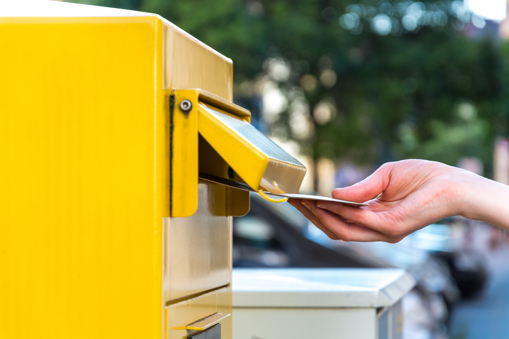 Throwing,A,Letter,In,A,German,Yellow,Mailbox