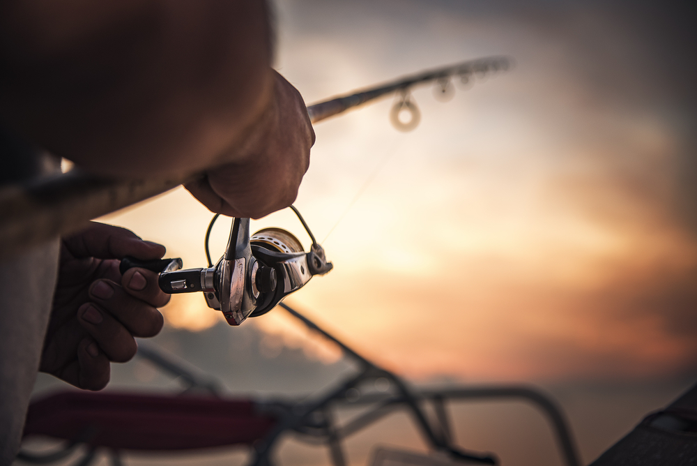 Fishing,Rod,Wheel,Closeup,,Man,Fishing,With,A,Beautiful,Sunrise