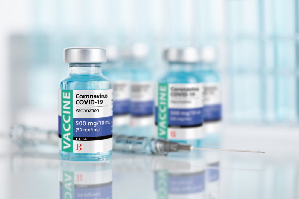 Coronavirus,Covid-19,Vaccine,Vials,And,Syringe,On,Reflective,Surface.