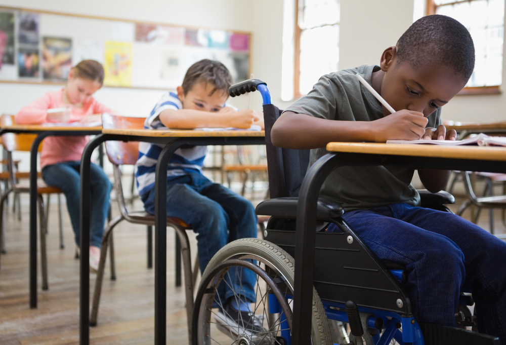 Cute,Pupils,Writing,At,Desks,In,Classroom,At,The,Elementary