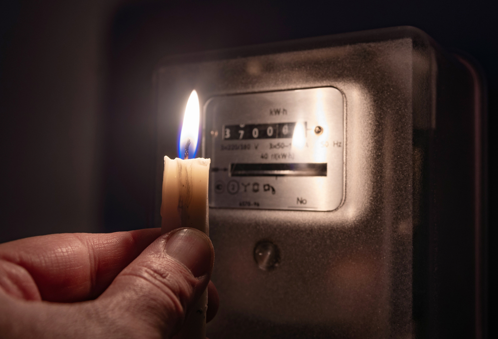 A,Man&rsquo;s,Hand,With,Candle,In,Complete,Darkness,Looking,On
