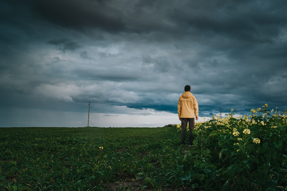 A,Lonely,Man,In,Yellow,Jacket,Exploring,Rural,Area,In