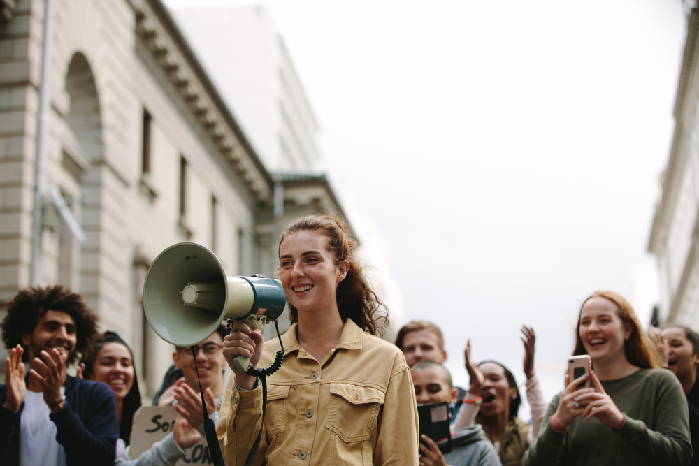 Young,Woman,With,Group,Of,People,In,A,Rally.,Woman