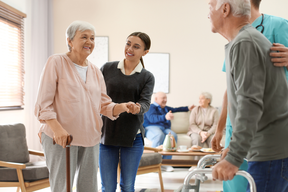 Care,Workers,Helping,To,Elderly,Patients,To,Walk,In,Geriatric