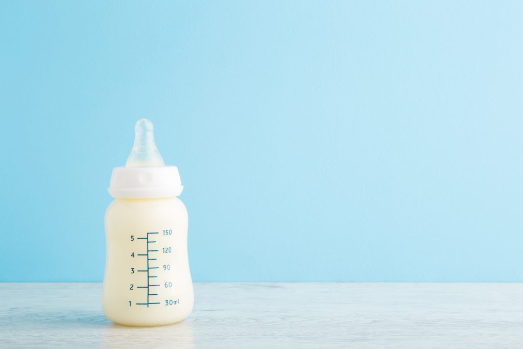 Bottle,Of,White,Milk,On,Wooden,Table,At,Light,Blue