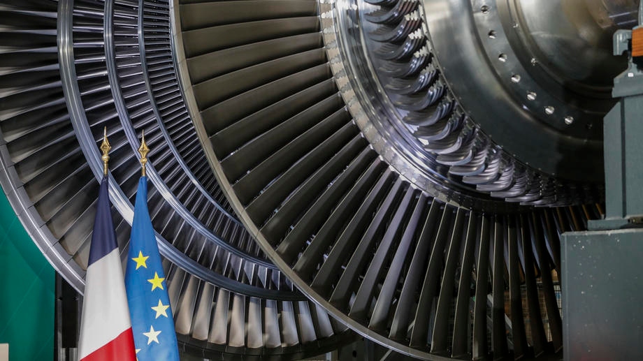 epa09744132 The European and French national flags are seen next to a nuclear turbine at the GE Steam Power System site in Belfort, eastern France, 10 February 2022, prior to French President Emmanuel Macron unveiling plans to build new nuclear reactors in the country as part of its energy strategy to reduce planet-warming emissions.  EPA-EFE/Jean-Francois Badias / POOL MAXPPP OUT