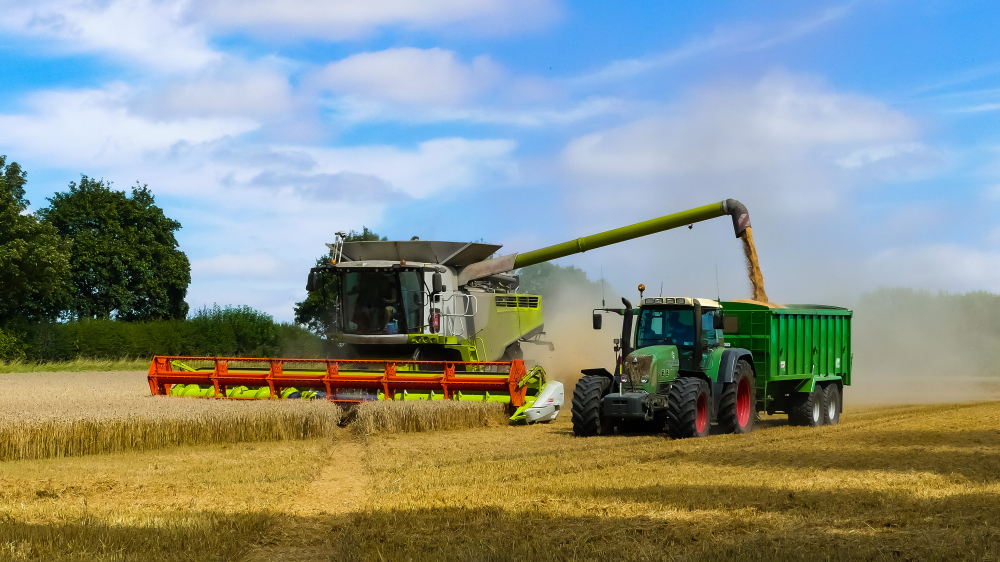 Tractor,With,Trailer,Working,In,Tandem,Alongside,A,Working,Combine