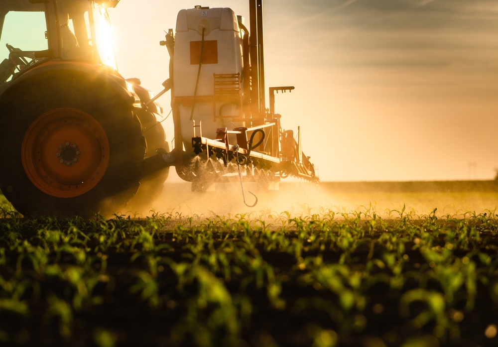 Tractor,Spraying,Pesticides,On,Corn,Field,With,Sprayer,At,Spring
