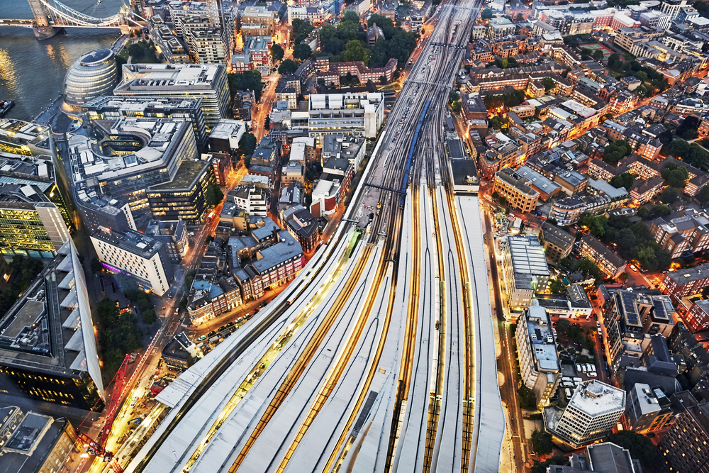 Aerial,View,Of,Train,Tracks,Entering,London,Bridge,Illuminated,At
