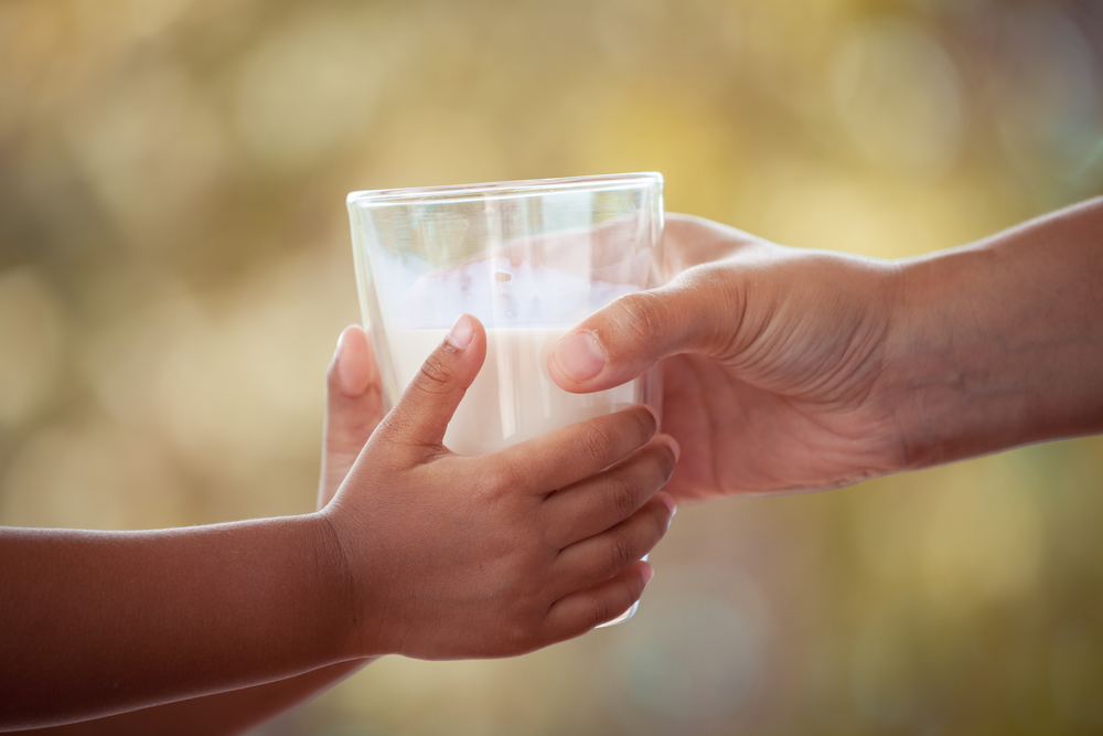 Woman,Hand,Giving,Glass,Of,Milk,To,Child,In,Vintage