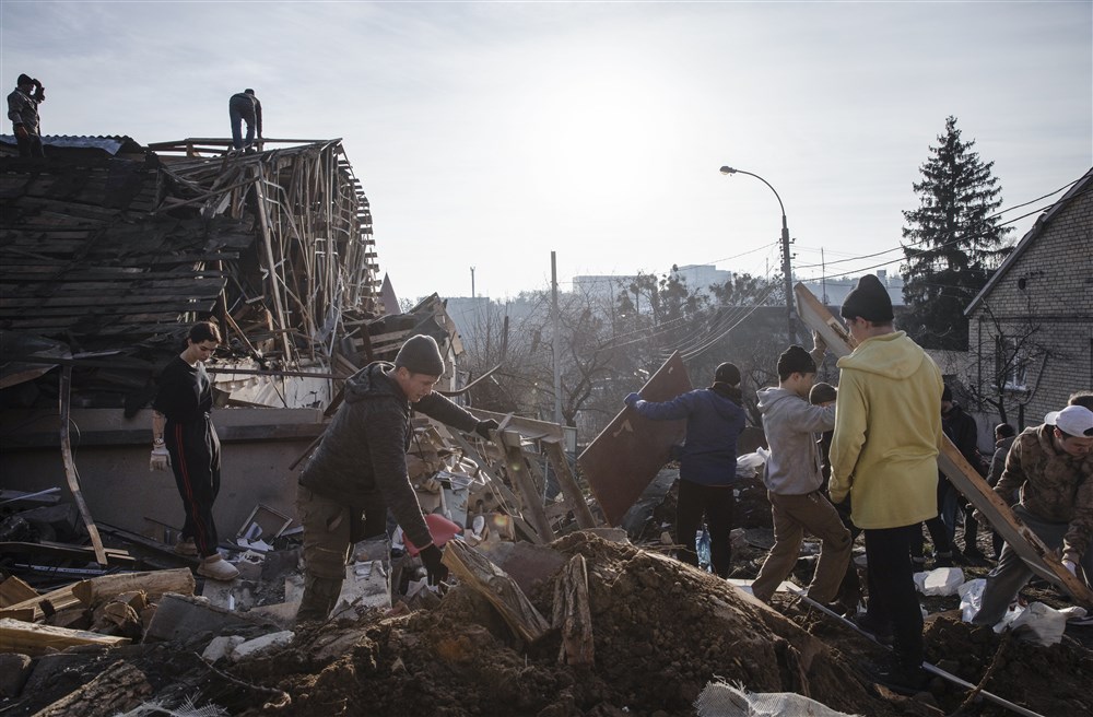 Volunteers clear debris at the site of a Russian New Year&rsquo;s Eve missile attack in Kyiv