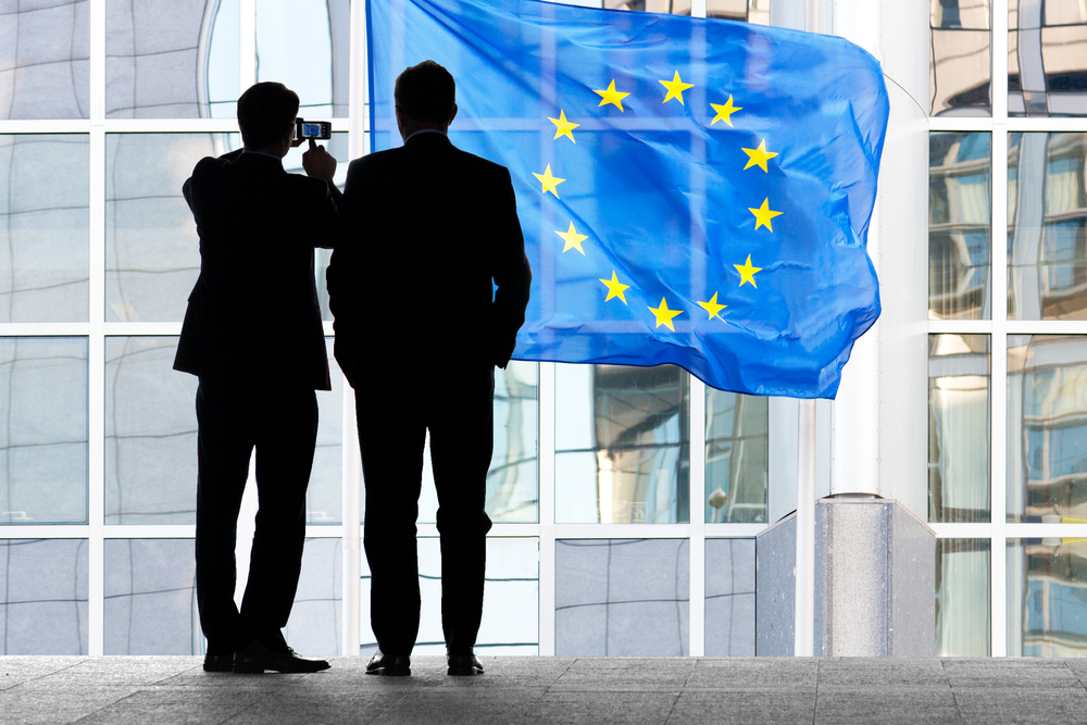People,Walking,To,Work.,Flags,With,European,Parliament,In,Brussels.