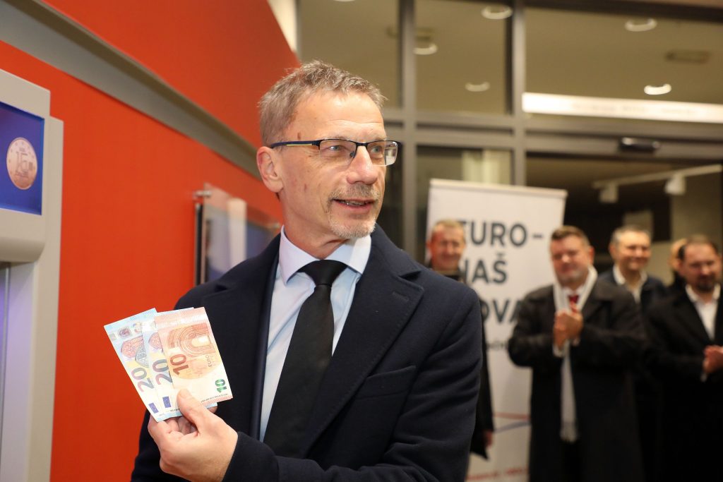 Croatian National Bank Governor Boris Vujcic and Finance Minister Marko Primorac take the first euro banknotes at ATM
