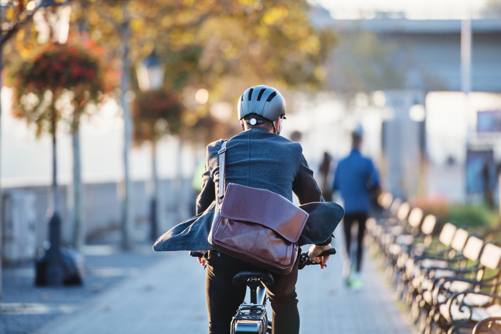 A,Rear,View,Of,Businessman,Commuter,With,Electric,Bicycle,Traveling