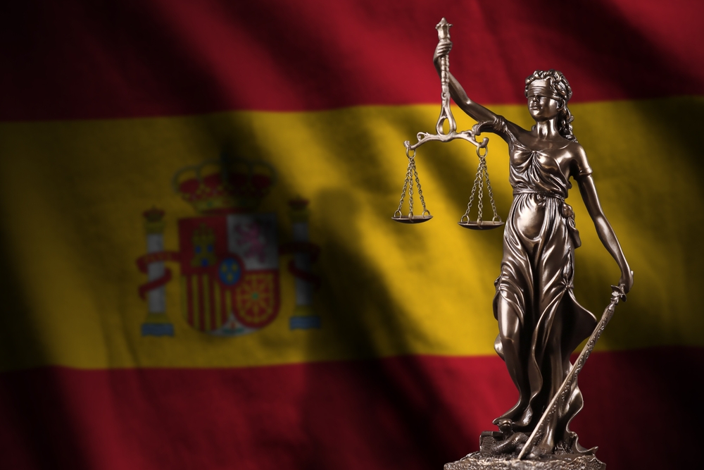 Spain,Flag,With,Statue,Of,Lady,Justice,And,Judicial,Scales