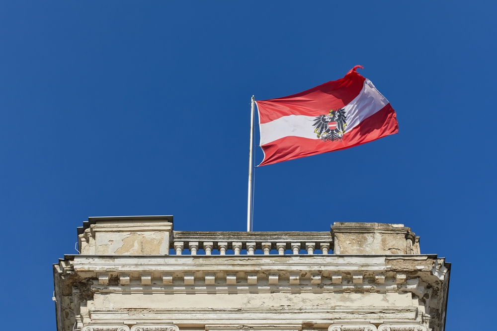 Austrian,Flag,Waving,Against,Blue,Sky