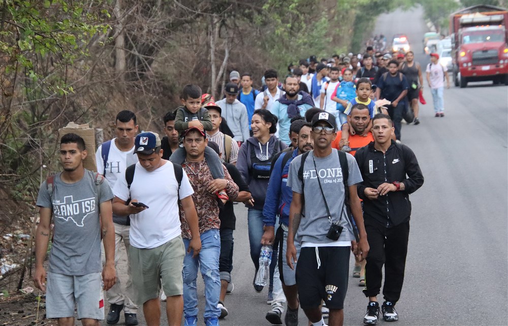 Migrantes walk in a caravan as they leave Tapachula