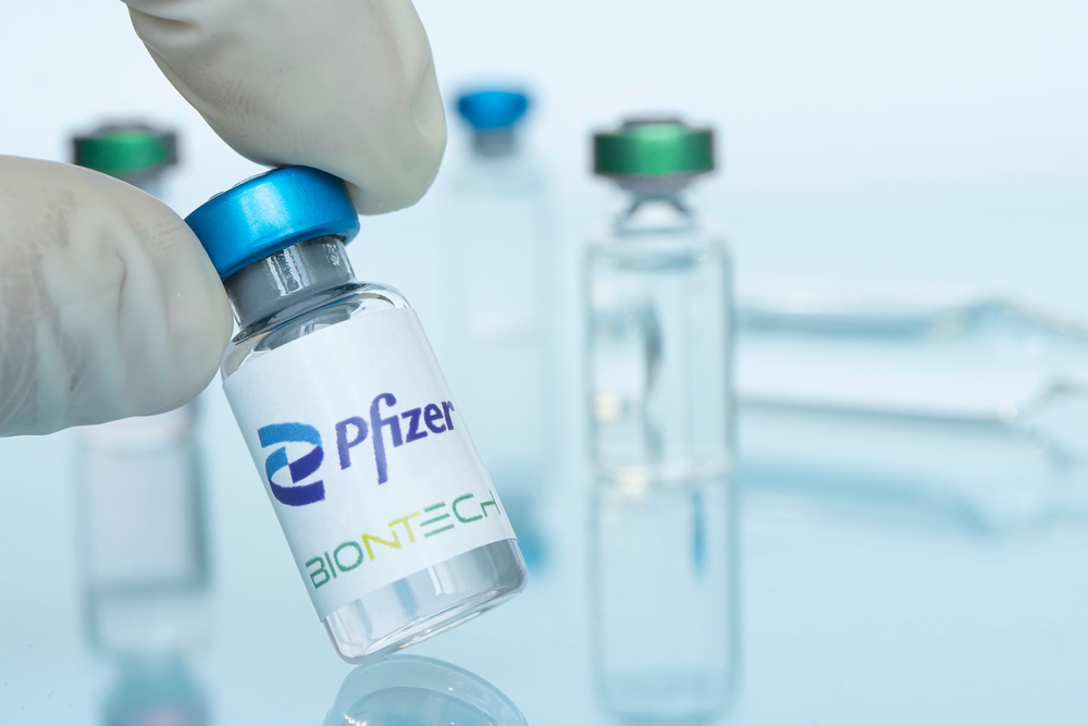 Glass,Bottle,With,Logo,Pfizer,And,Biontech,In,The,Doctor&rsquo;s