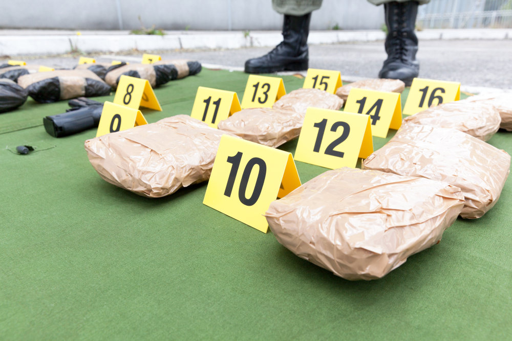 Police,Officer,Standing,Guard,Over,Seized,Packages,Of,Drug