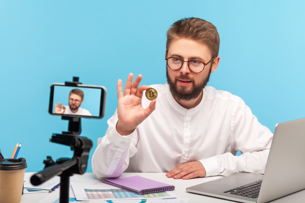 Bearded,Man,Blogger,Holding,In,Hands,And,Showing,On,Smartphone